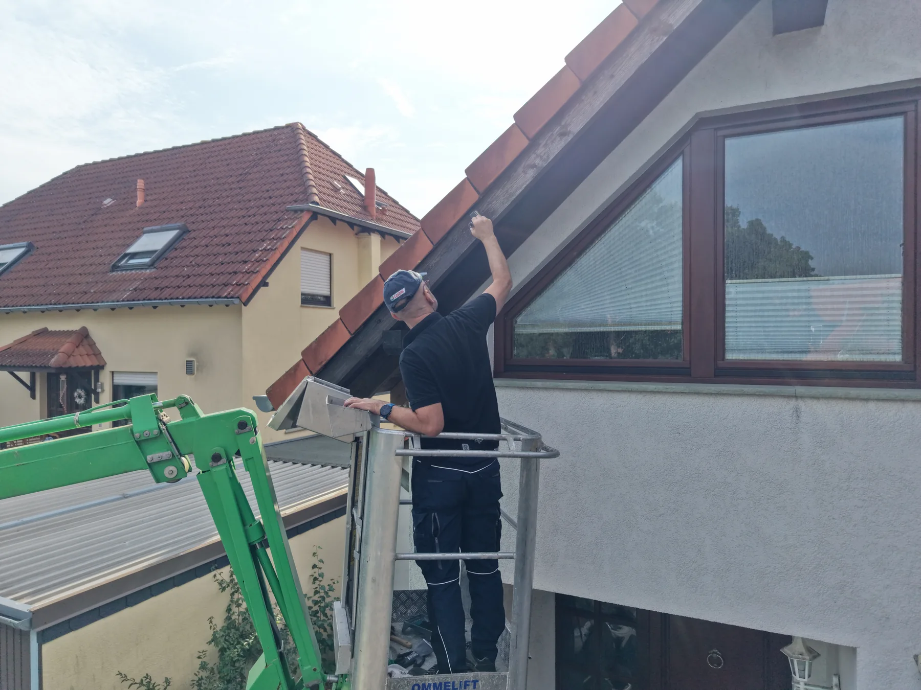 Bearbeitung eines Holzbauteils am Giebel von der Arbeitsbühne aus